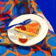 Orange cake on the lap of a woman with an orange pattern dress. Image by Ida Henrich